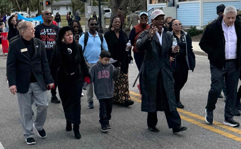 Demonstrators walk down Martin Luther King Jr. Way just past Orange Avenue.