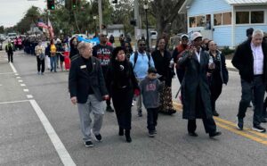 Demonstrators walk down Martin Luther King Jr. Way just past Orange Avenue.