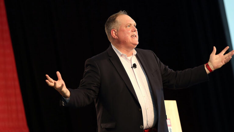 Tim McCarthy speaking, arms raised.