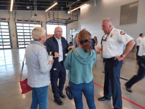 Four people talking inside a fire station.