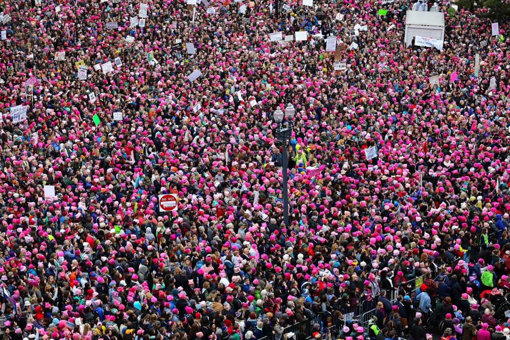 Aerial photo of a see of people wearing bright pink hats at the Women's March in 2017.