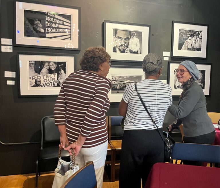 Lily Evans stands with guests in front of Evans' photos.