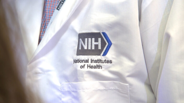 Close-up of the NIH emblem on a lab coat.