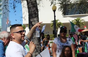 Junior Salazar speaks into a microphone, addressing fellow protestors outside the Sarasota County Library downtown.