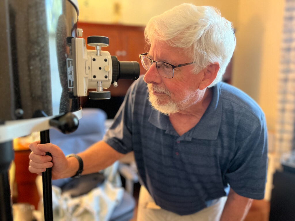 David Dean looking through his telescope.