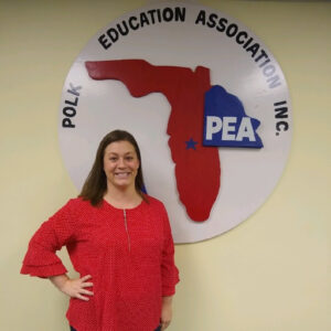 Stephanie Yocum posing next to a Polk Education Association Inc sign.