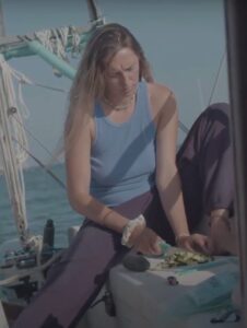 CC Reid cutting vegetables on a boat.