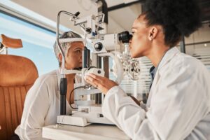 Photo of an optometrist conducting an eye exam for an attentive patient.