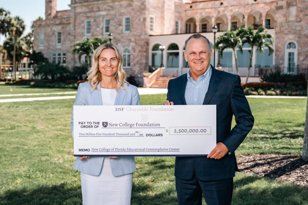 Richard Corcoran and Sydney Gruters holding a giant check made out to the New College Foundation in the amount of $2.5 million.