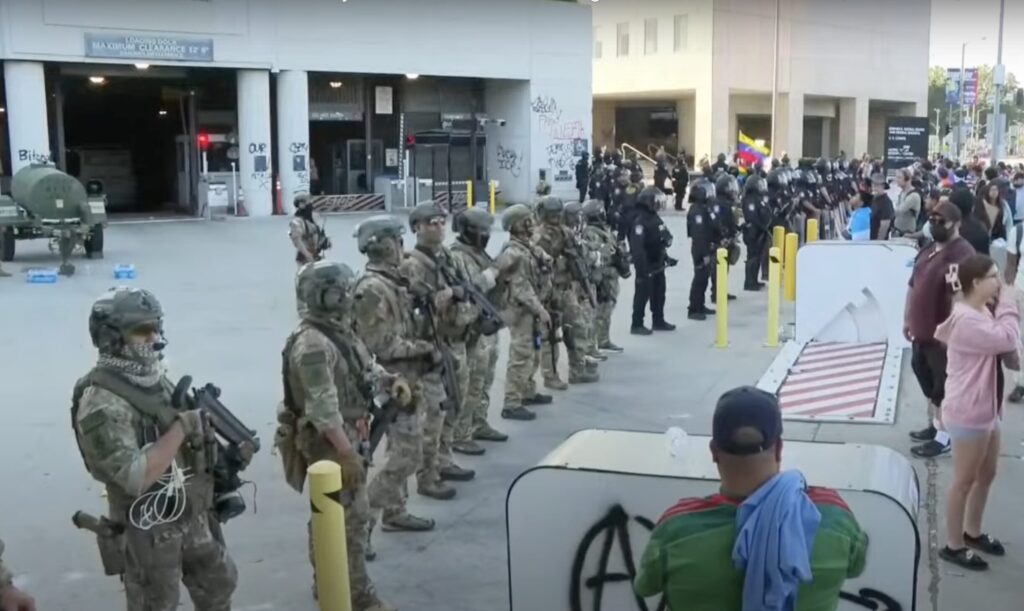 National Guard soldiers stand in a line to block protesters from approaching the federal building in L.A.