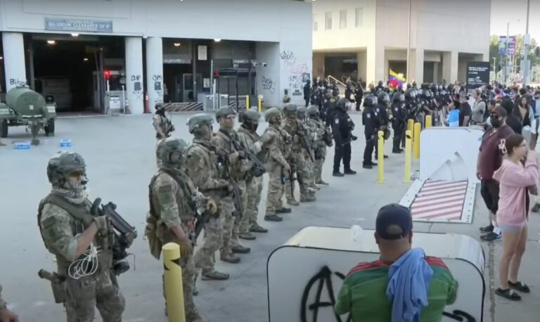 National Guard soldiers stand in a line to block protesters from approaching the federal building in L.A.