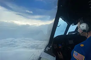 Shot of a pilot in the cockpit of a plane amid the clouds.