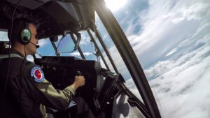 Shot of a pilot in the cockpit of a plane amid the clouds.