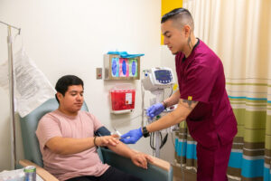 A medical care provider takes a patient's temperature using a finger thermometer.