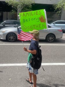 A protester holds up a sign that reads, "Families belong together."