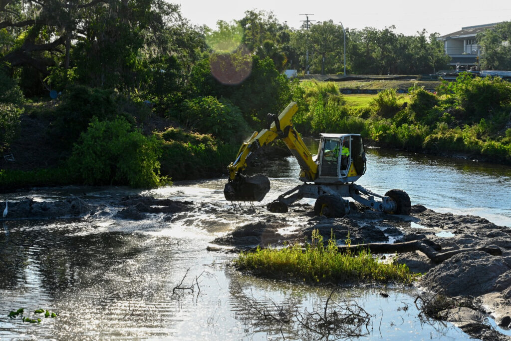 Sediment is removed from a creek by an excavator.