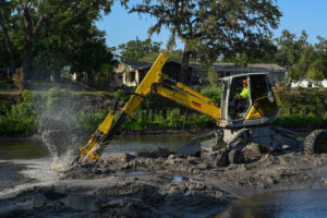 Sediment is removed from a creek by an excavator.