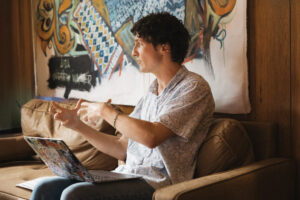Zander Moricz gesticulating while speaking, a laptop on his lap.