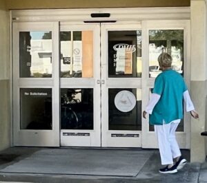 Photo of someone entering through a building's automatic doors.