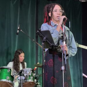 A singer and a drummer onstage.