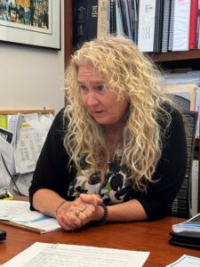 Jen Ahearn-Koch speaking while sitting at a desk.