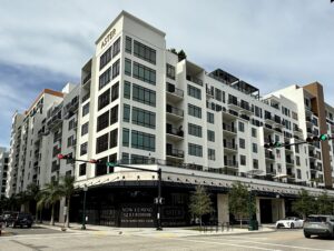 An apartment building with a sign above that says "Aster" and a sign below that advertises they are "Now leasing 1, 2, & 3 bedroom".