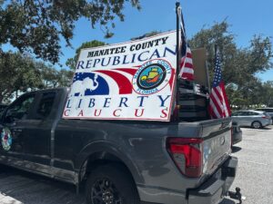 A sign in the bed of a pickup truck that reads "Manatee County Republican Liberty Caucus".