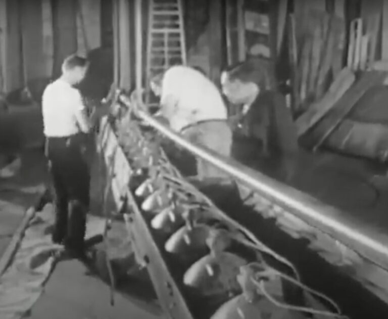 Black and white movie still of stagehands working on the lighting for a stage production.