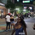 Photo of people out and about outside an Orlando mall at night.