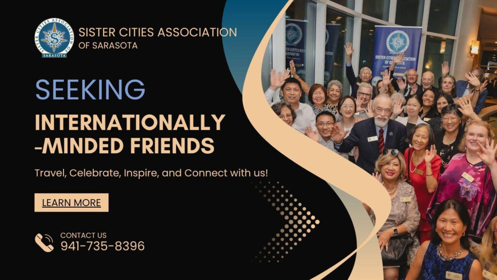 Photo of a crowd of people smiling in front of a Sister Cities Association of Sarasota banner with accompanying text that reads "Seeking internationally-minded friends / Travel, Celebrate, Inspire, and Connect with us! / Contact us / 941-735-8396"