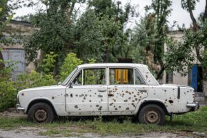 Photo of a car riddled with bullet holes.