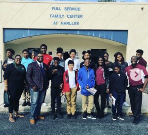 A group gathered outside the entrance to the Full Service Family Center at Harllee.
