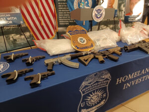 A Homeland Security Investigations table with several firearms on display.