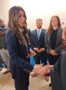 Kristi Noem shakes someone's hand.