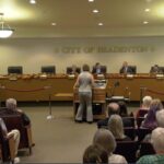 A person speaking at a podium at a meeting at Bradenton City Hall.