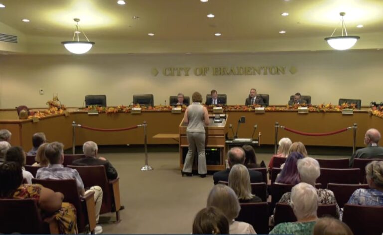 A person speaking at a podium at a meeting at Bradenton City Hall.