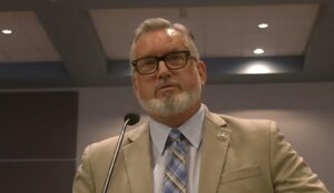 Mike Rahn speaking into a microphone.