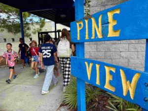 Students walking past a sign at Pine View's entrance.
