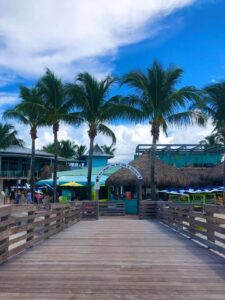 A wooden walkway leading to an entryway leading to a restaurant with a sign that reads "You Caught The BIG ONE At Sharky's!".