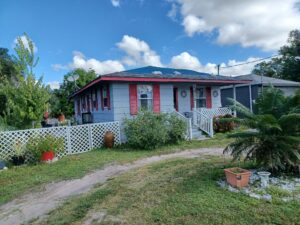 A house with a tarp covering a damaged roof.