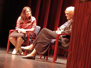 Sora Vigorito sitting with another person on stage.