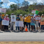 A crowd of anti-ICE demonstrators along the side of the road.