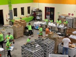 Workers packaging bulk canned goods.