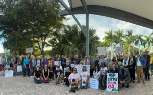 A group of demonstrators in downtowwn Sarasota poses with pro-immigrant signs.