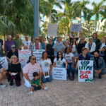 A group of demonstrators in downtowwn Sarasota poses with pro-immigrant signs.