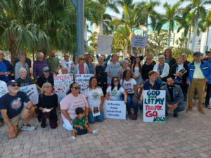 A group of demonstrators in downtowwn Sarasota poses with pro-immigrant signs.