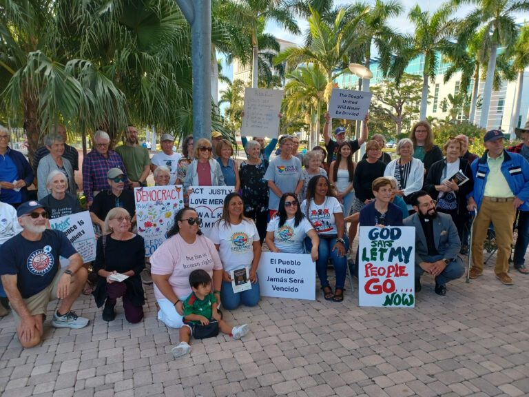 A group of demonstrators in downtowwn Sarasota poses with pro-immigrant signs.
