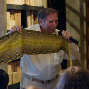 Stephen "Dr. Beach" Leatherman holds up a python skin while addressing a crowd.