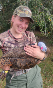 Juliana Ofalt cradling a turkey and smiling.