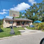 A house with a basketball hoop out front.